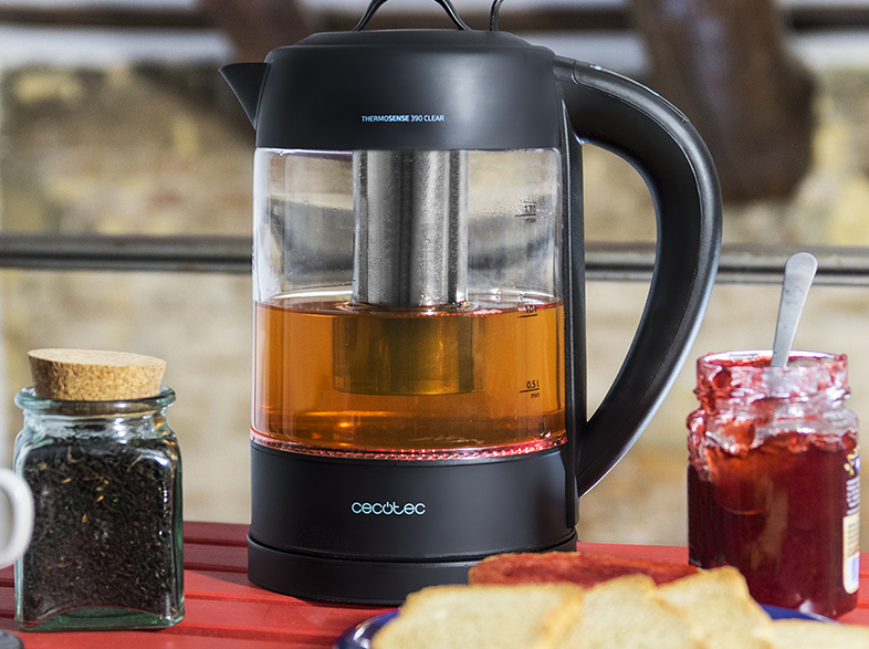 Una tetera con té dentro. Té, mermelada y especias sobre la mesa.