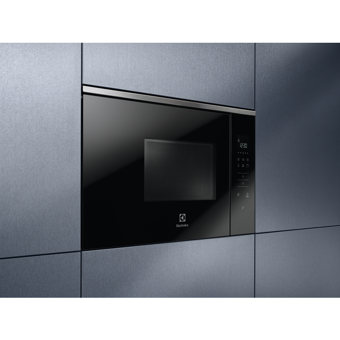 Fekete Electrolux mikrohullámú sütő sötétszürke szekrénybe építve. A kijelző az időt mutatja.