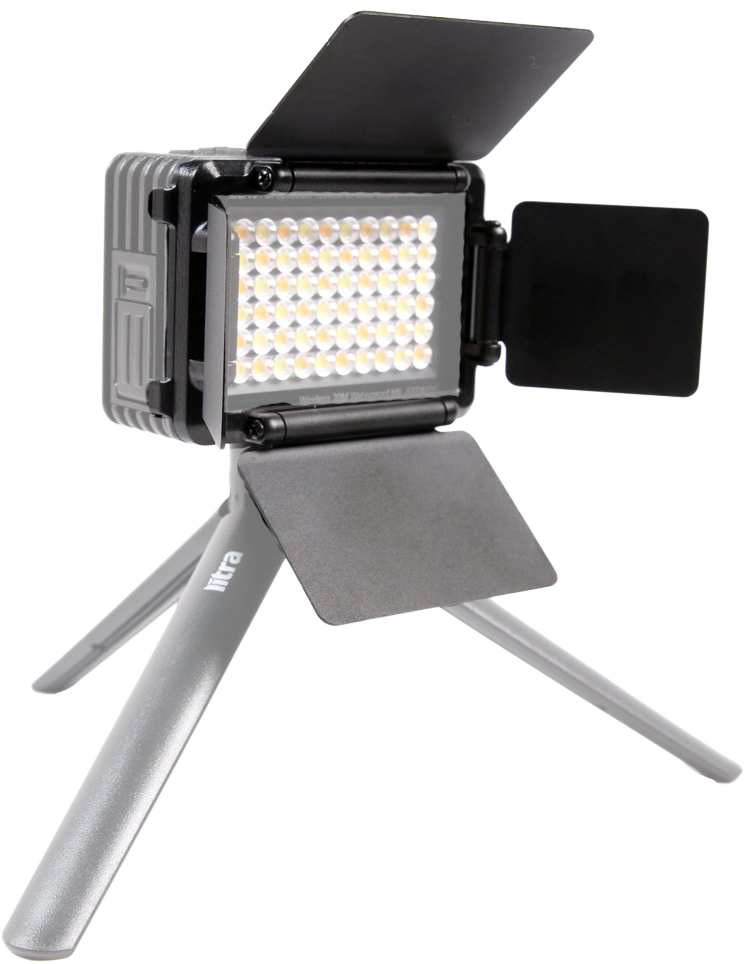 Egy kis LED-lámpa állványon. A lámpának fekete lapjai vannak, és egy szürke állványon nyugszik. A fény meleg ragyogást bocsát ki.