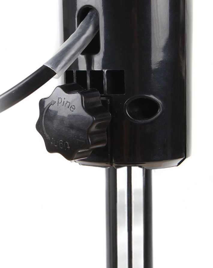 Primer plano de un dial negro en un dispositivo negro con un cable.