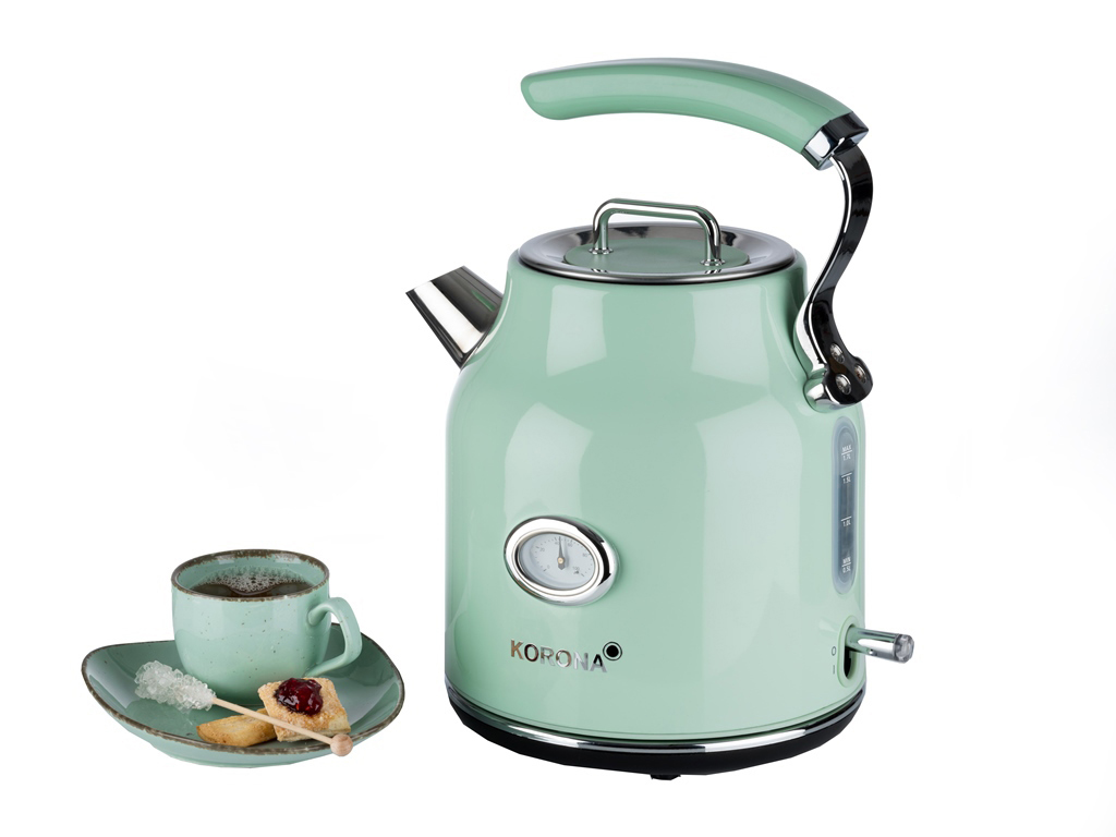 Eine mintgrüne Teekanne mit Griff und eine Tasse Tee mit Keksen.