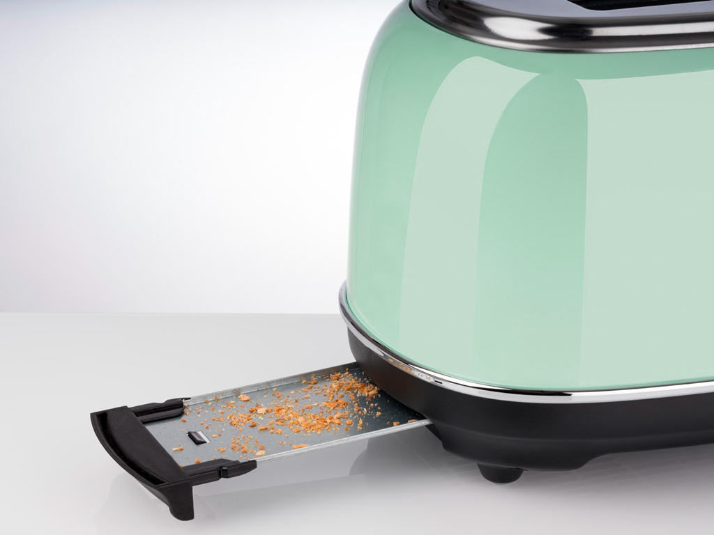 Minzgrüner Toaster mit teilweise herausgezogener Krümelschublade auf weißem Grund.