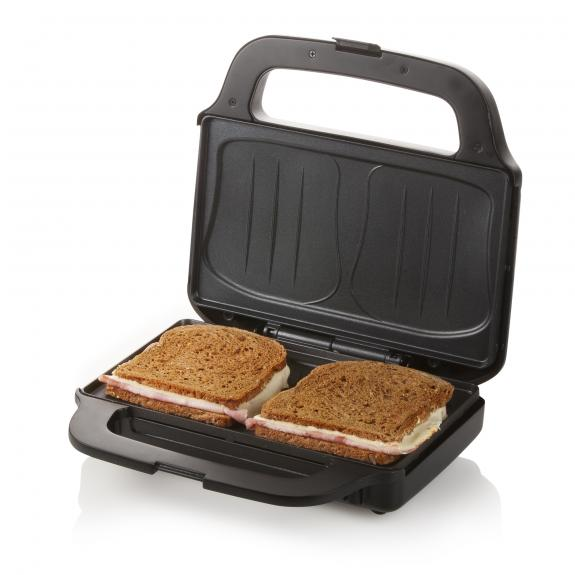Black sandwich maker with two sandwiches inside, on a white background.