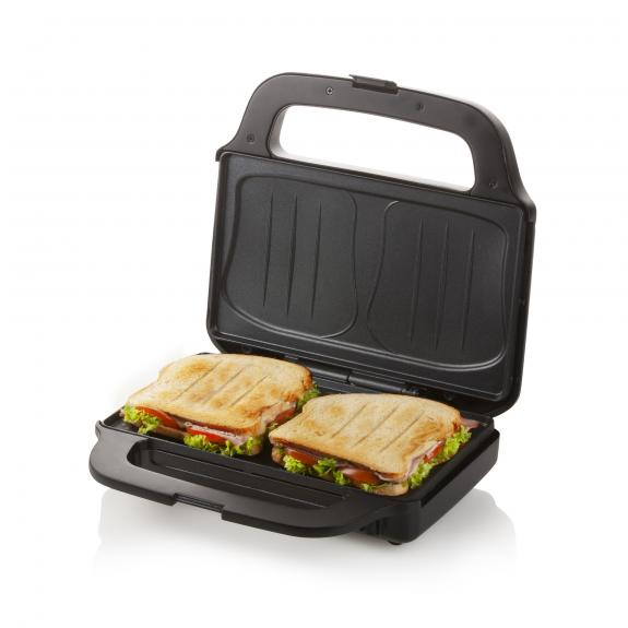 Black sandwich maker with two sandwiches inside. The sandwiches have filling.