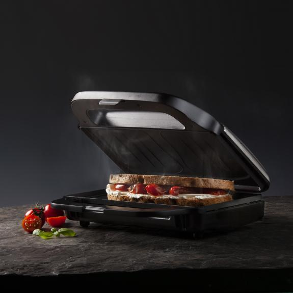 Black sandwich maker with open lid and sandwich.