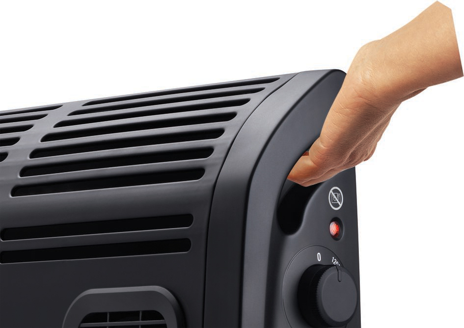 Black heater with a hand adjusting the temperature dial. White background.