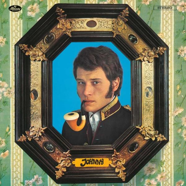 Portrait de Johnny Hallyday dans un cadre décoratif, tenant une pipe. Le fond est un papier peint floral.