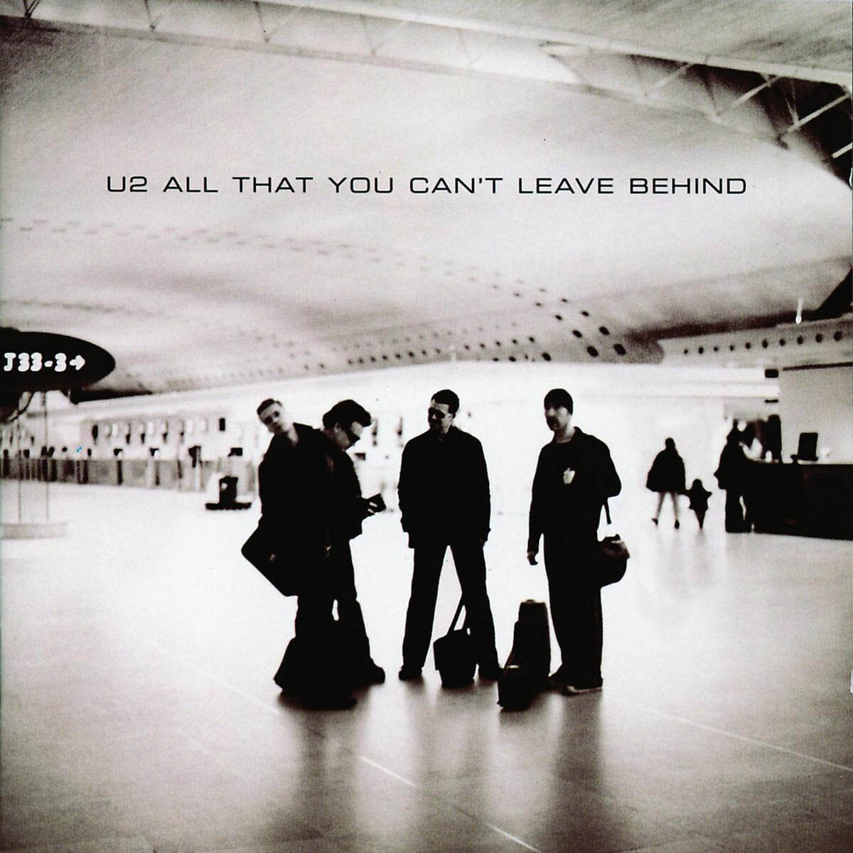 Pochette de l'album U2. Membres du groupe à l'aéroport, avec le texte : All That You Can't Leave Behind.