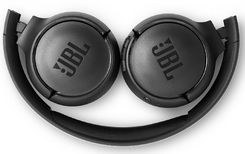 Auriculares JBL negros plegados. Se ven las copas y la diadema contra un fondo blanco.