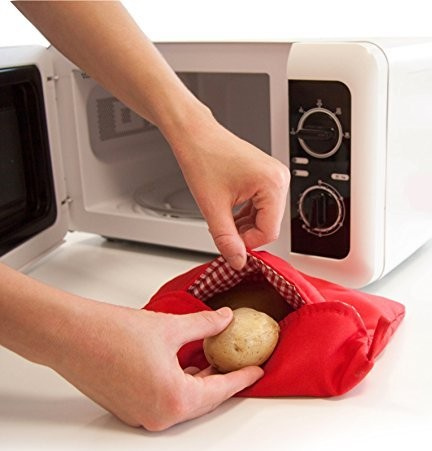 Persona colocando patata en bolsa para microondas dentro del microondas.