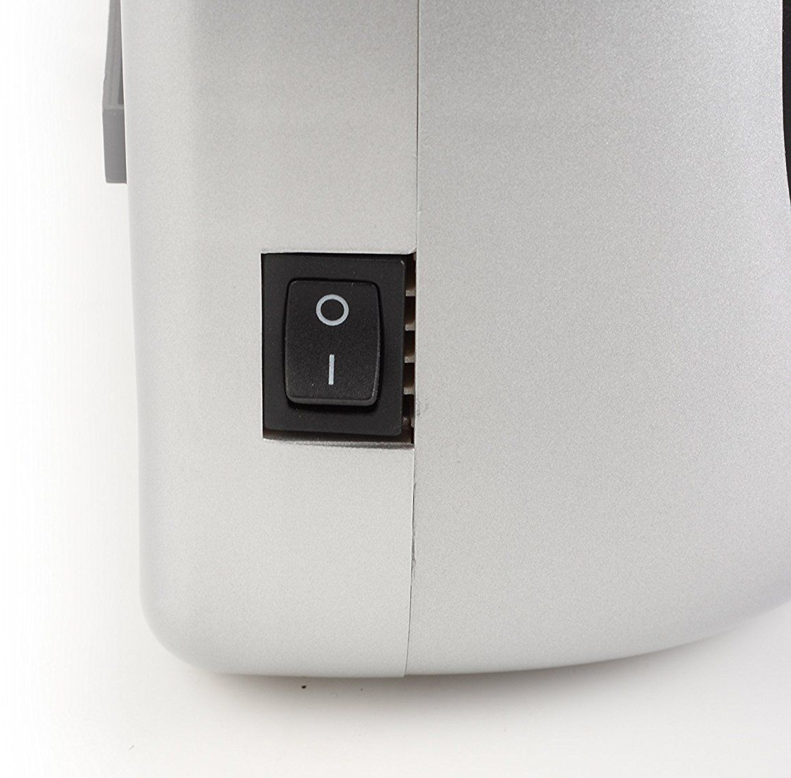 Un primo piano di un interruttore di alimentazione nero su un apparecchio elettrico grigio chiaro.
