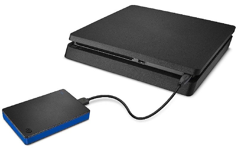 Consola PlayStation 4 negra conectada a un disco duro externo negro y azul.