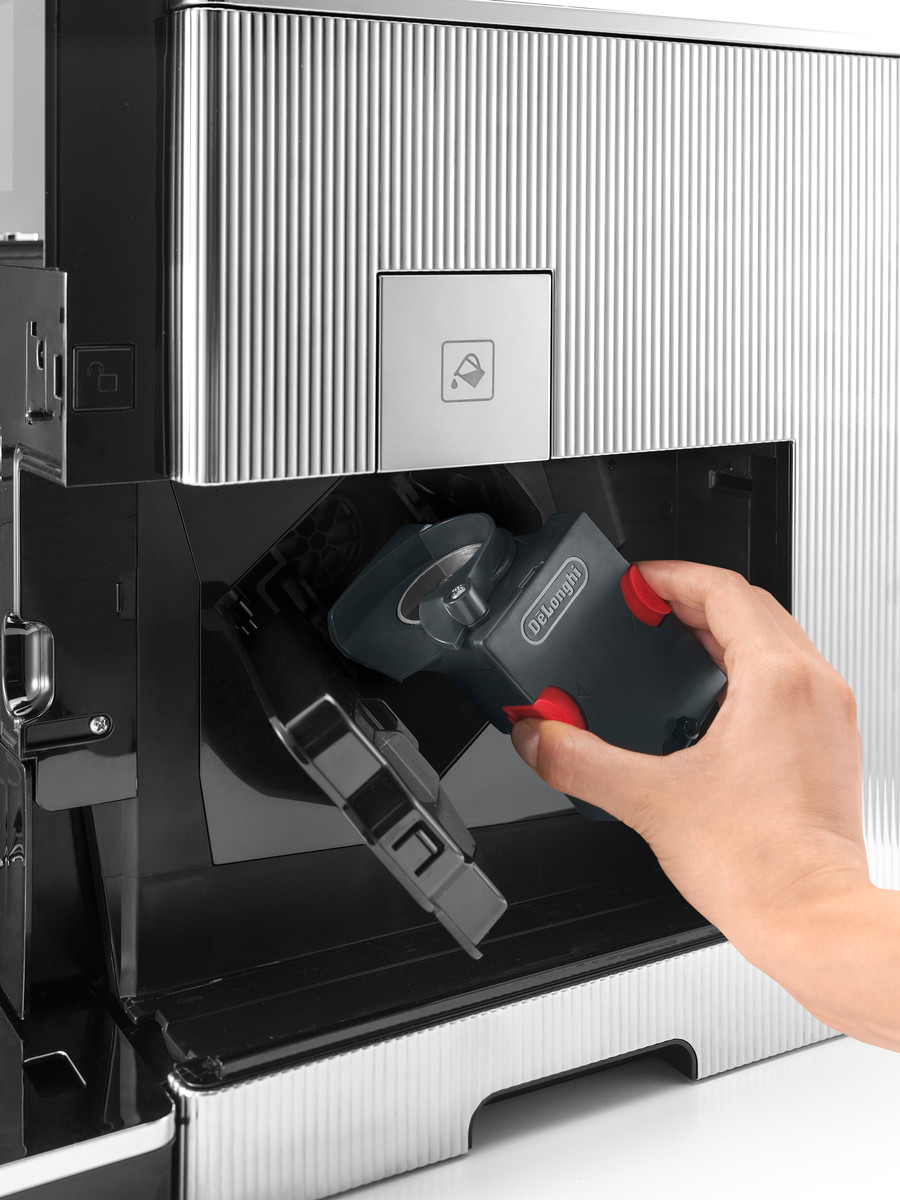 Hand, die eine schwarze Kaffeemaschinenkomponente mit roten Akzenten entfernt.