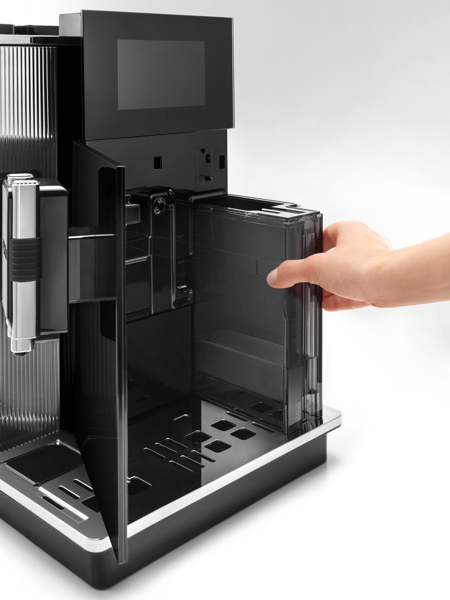 Eine schwarze Kaffeemaschine, bei der eine Hand den Wassertank entfernt.