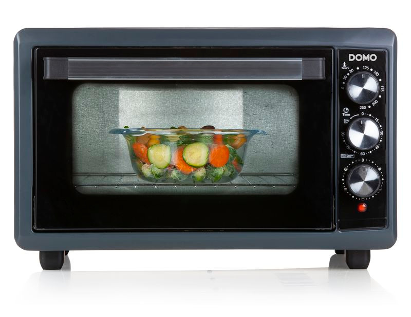 Oven with vegetables in a glass dish, controls on the right.