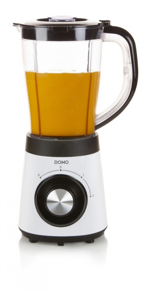 Un mélangeur blanc avec du liquide orange. Le mélangeur est sur une surface blanche.