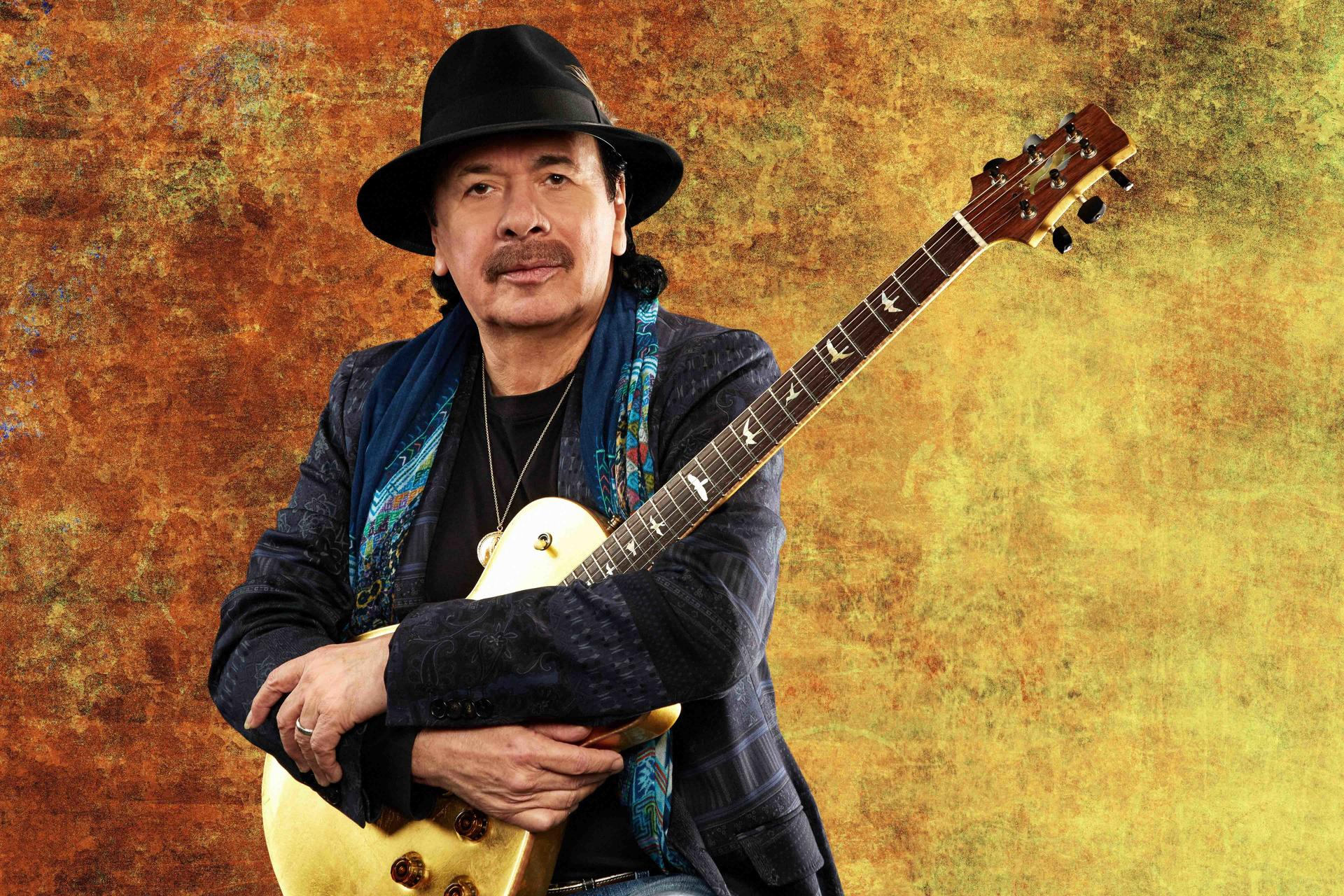 Carlos Santana mit Gitarre und Hut.