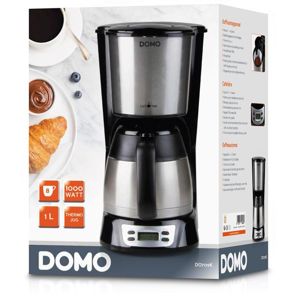 A DOMO coffee maker with a coffee cup, croissant, and blueberries on a plate.