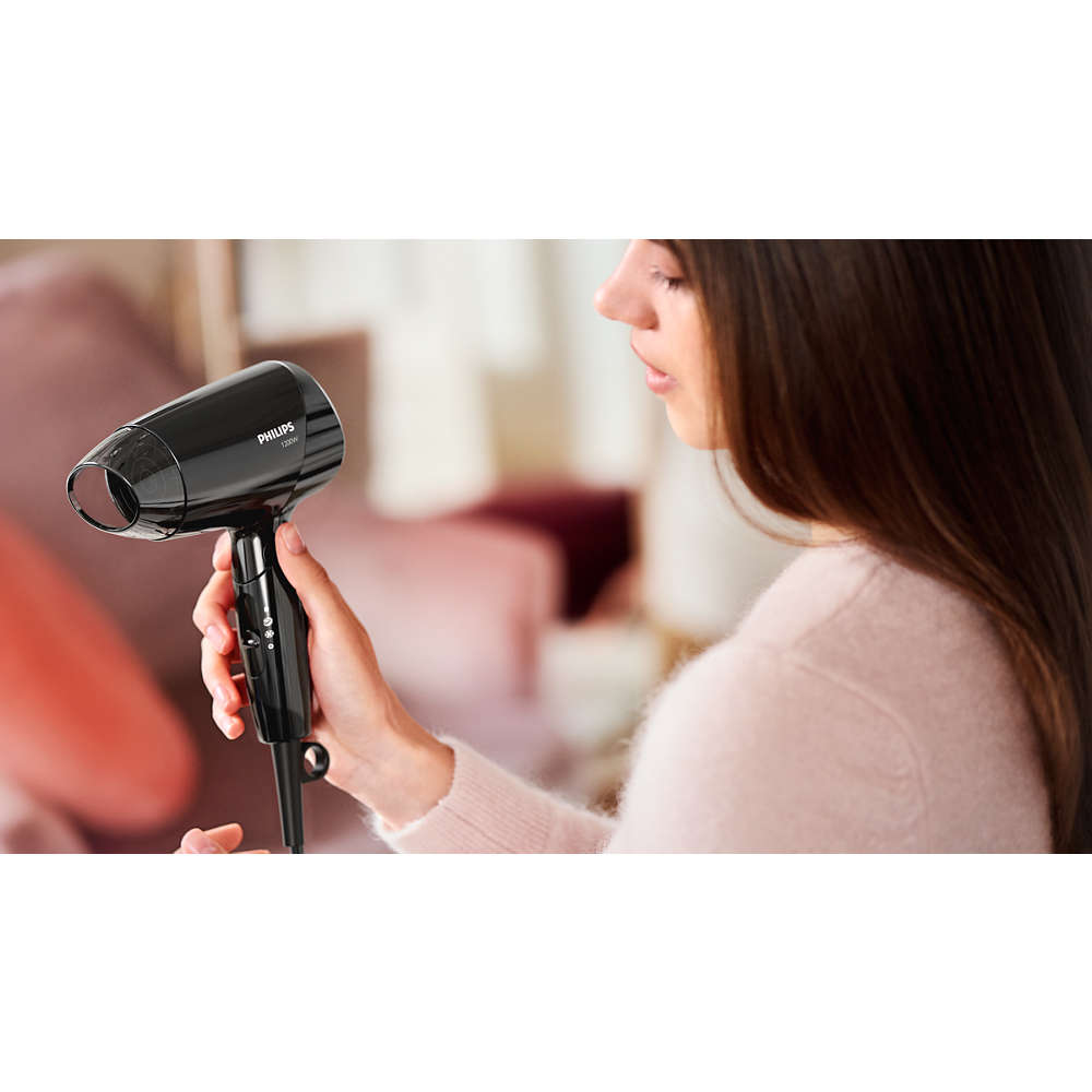 Rózsaszín pulóveres nő fekete Philips hajszárítót tart.