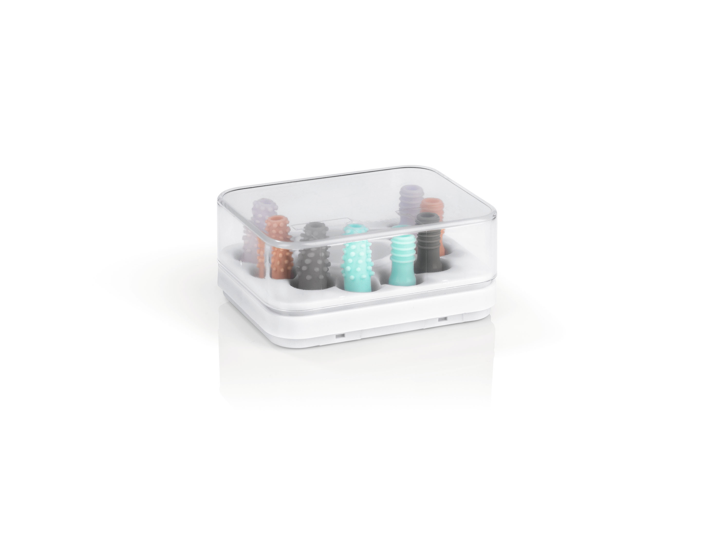 Eine weiße Box mit einem transparenten Deckel enthält mehrere bunte, strukturierte zylinderförmige Objekte.