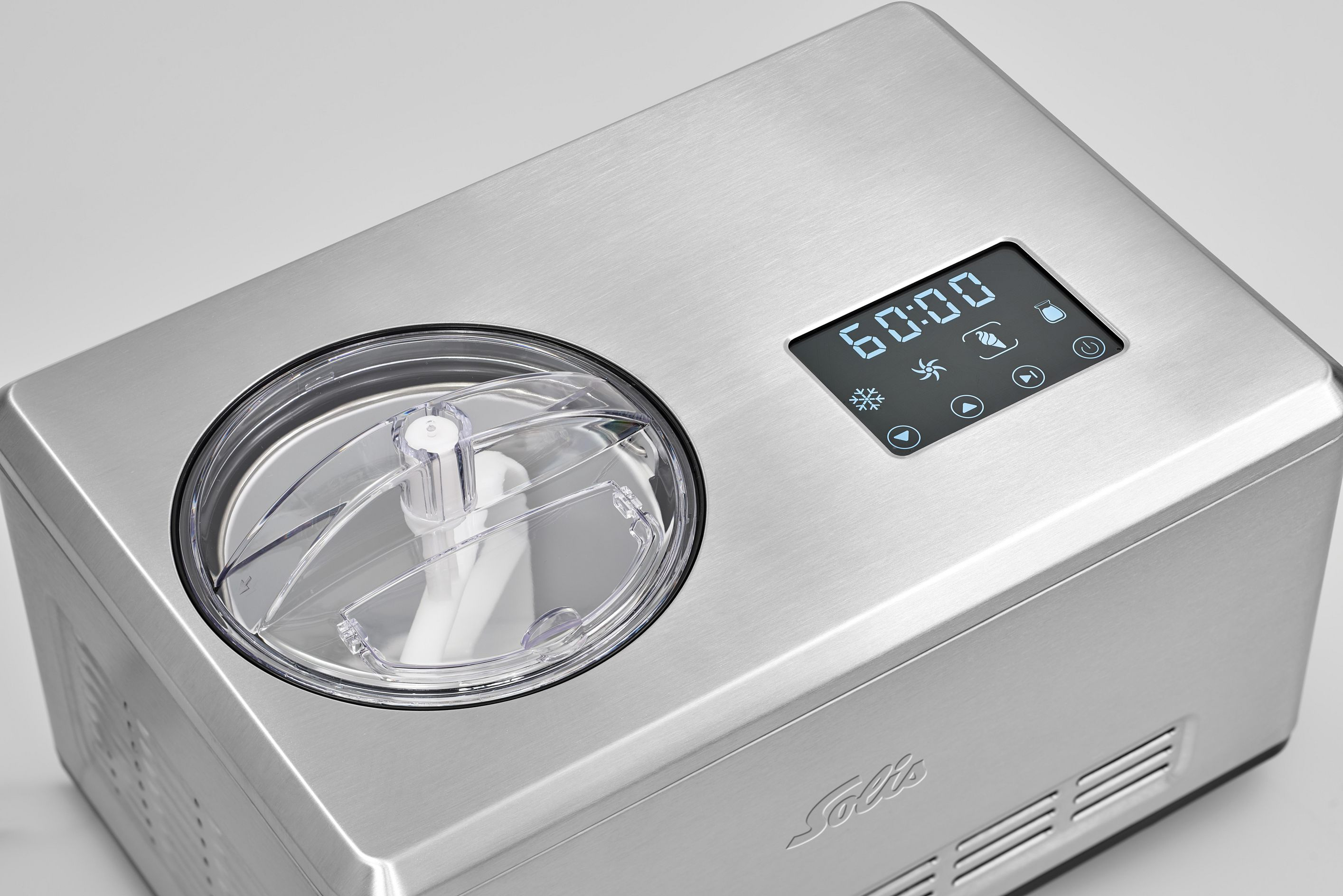 Machine à crème glacée argentée avec affichage numérique. Un couvercle transparent montre l'intérieur.