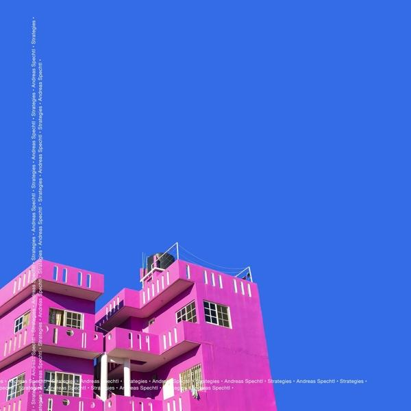 Helles rosa Gebäude vor blauem Himmel. Das Gebäude hat Fenster und ein flaches Dach, mit Text am Rand.