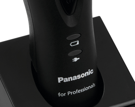 Nahaufnahme eines schwarzen Rasierers auf einer Ladestation mit Panasonic-Logo und Ladeanzeigen.