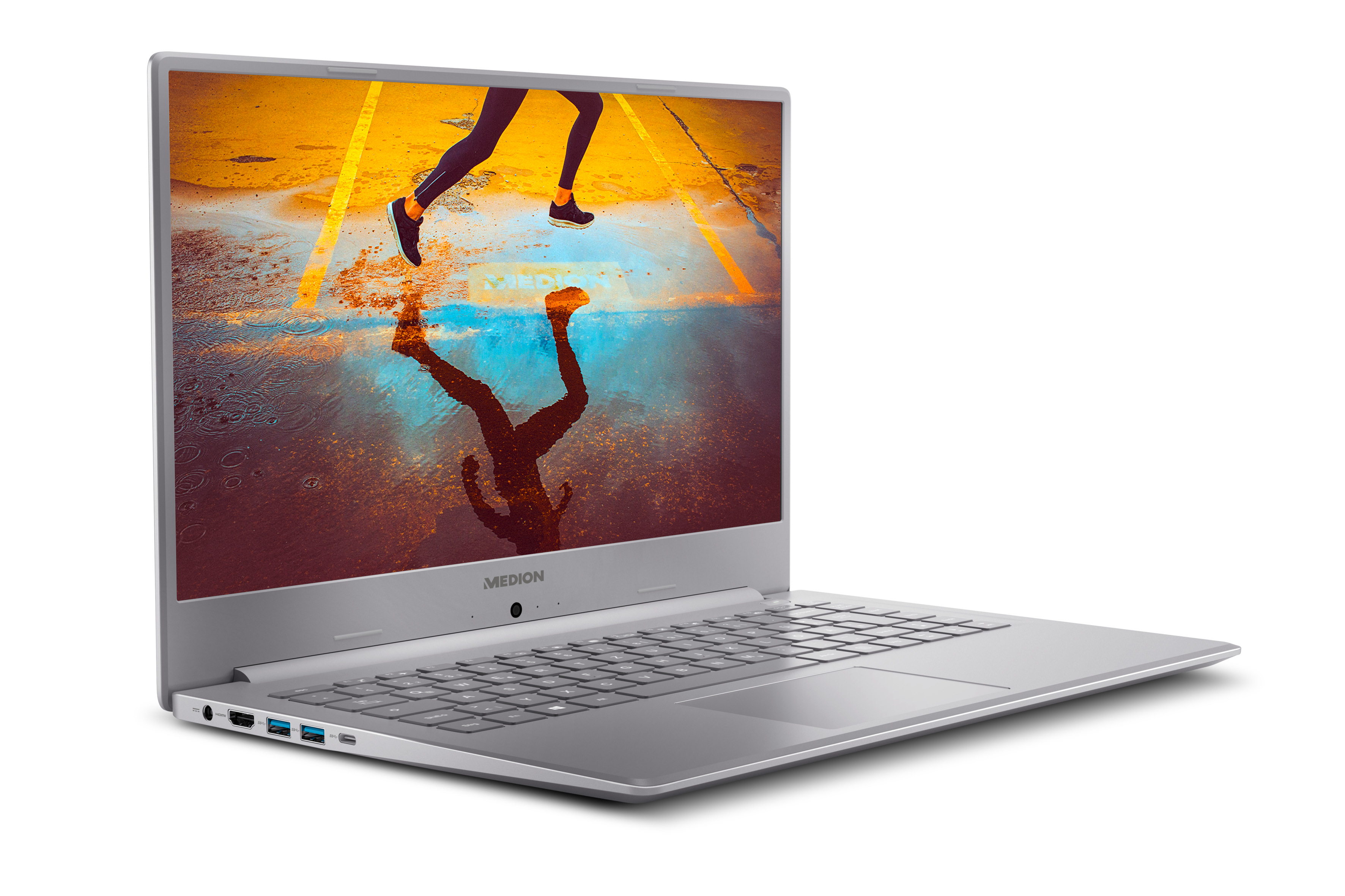 Silberner Laptop auf weißer Oberfläche, der eine Läuferreflexion zeigt.
