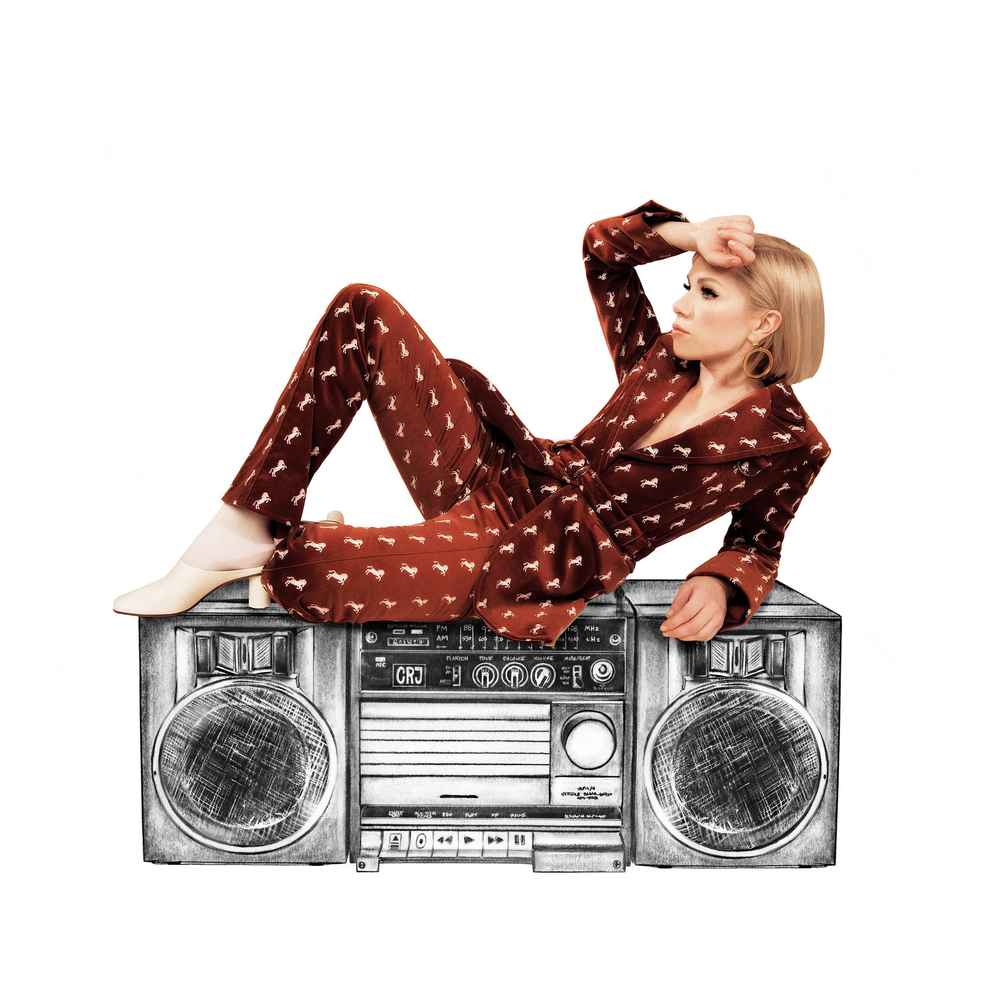 Eine Frau in braunem Anzug liegt auf einer Boombox.