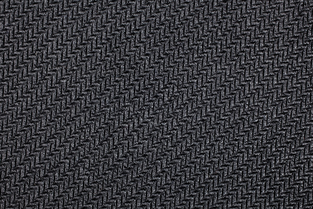 Gros plan sur un matériau noir texturé. La texture est un motif tissé répétitif.