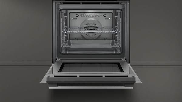 Offener Backofen mit Innenregalen und Tablett, dunkelgrauer Hintergrund.