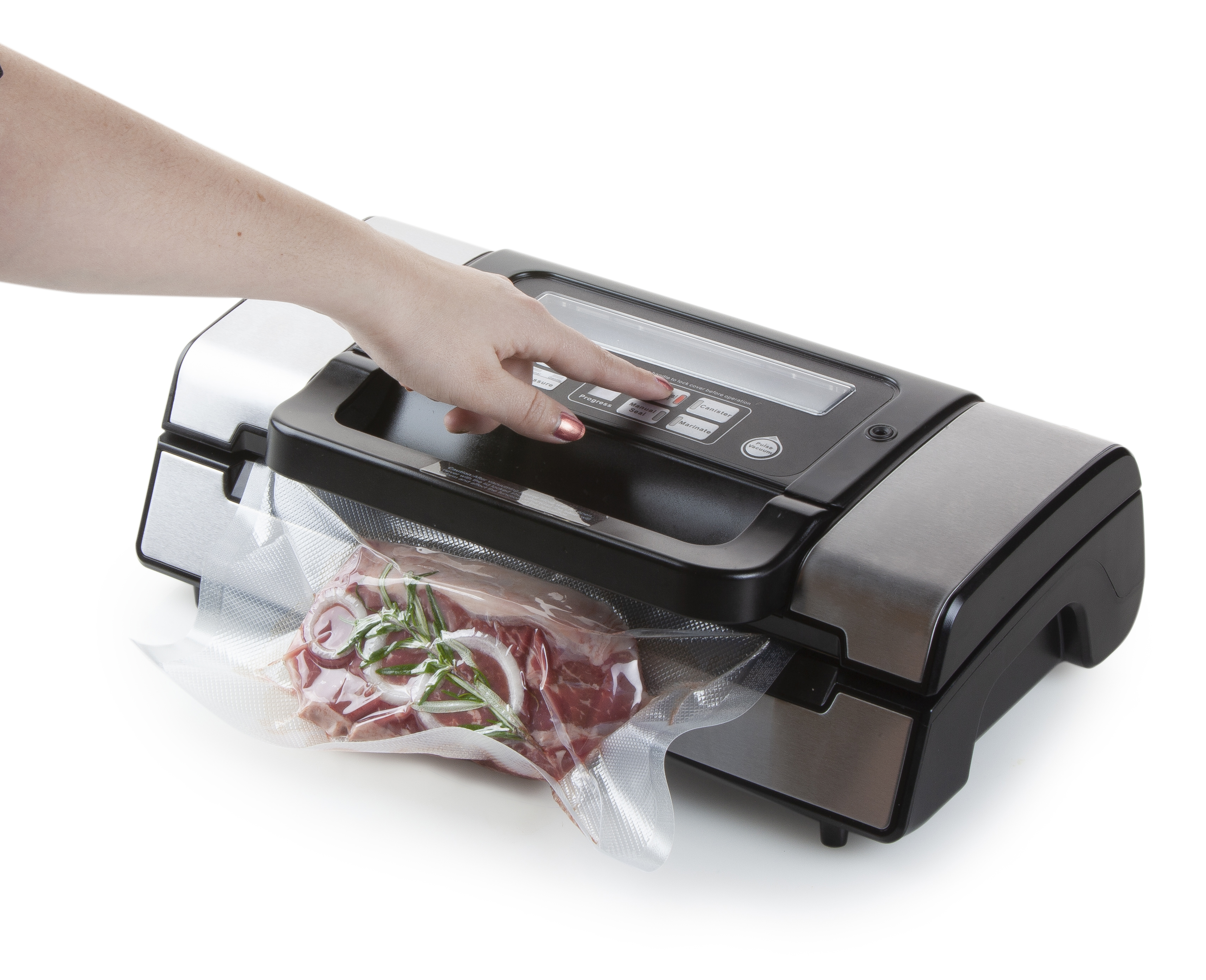 La main d'une personne appuyant sur un bouton d'une scelleuse sous vide. La scelleuse contient un sac de viande.