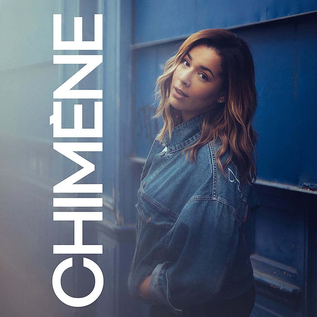 Femme en veste en jean, regardant la caméra. Le mot 'CHIMENE' est verticalement à gauche.