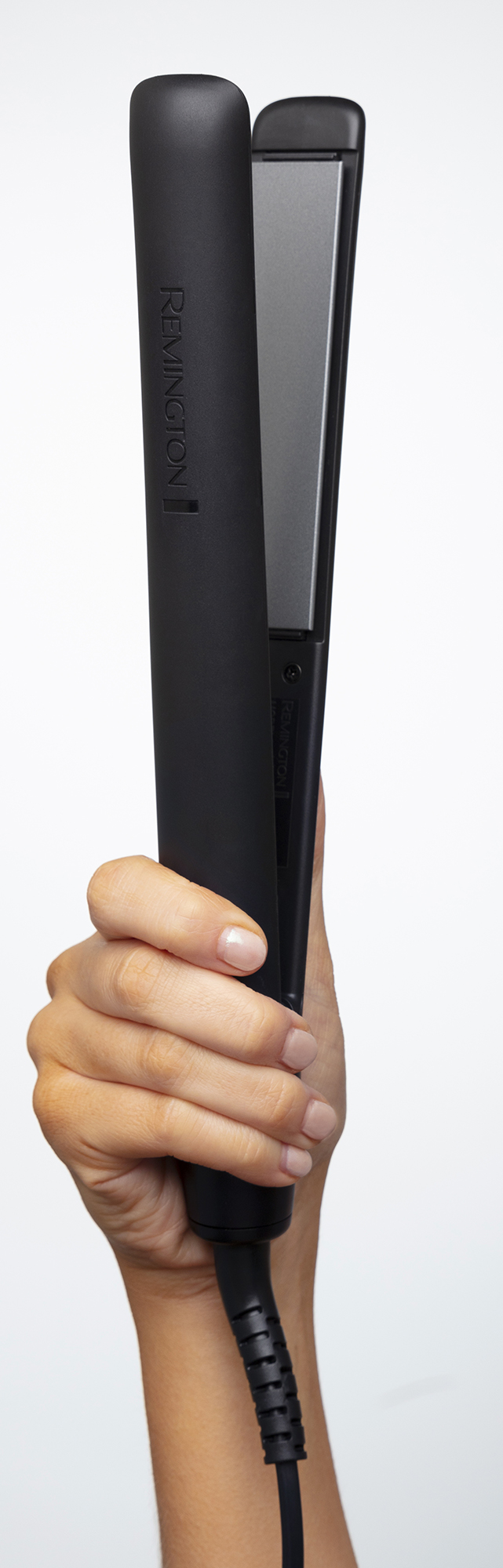 Hand holding black Remington hair straightener.