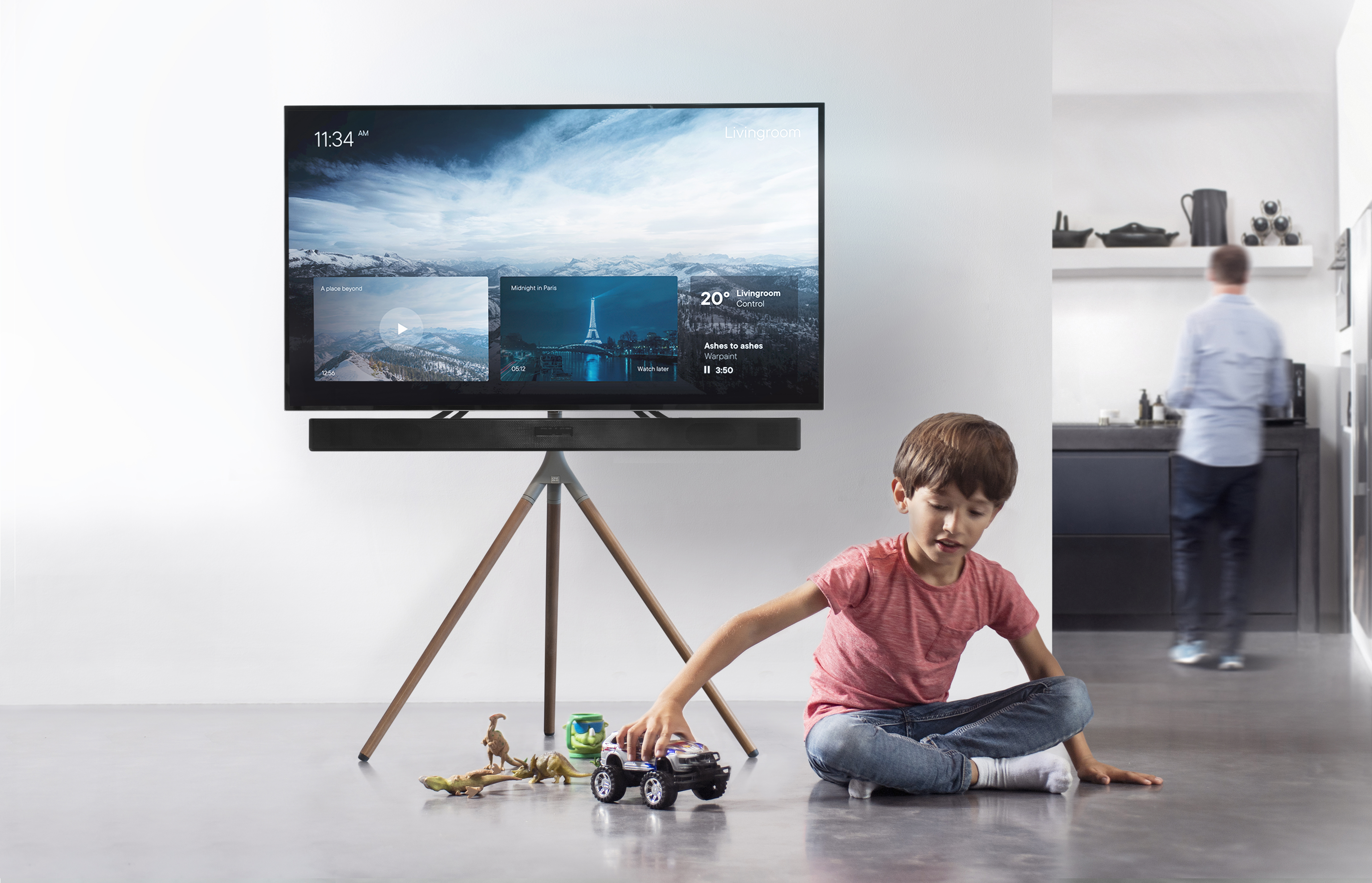 Ein Junge spielt vor einem Fernseher mit Spielzeug.