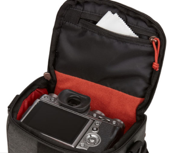 Black camera bag, open, with camera inside and cleaning cloth in a pocket.