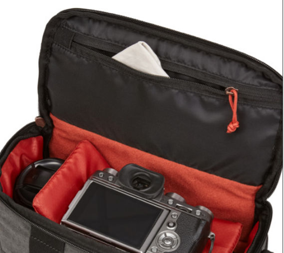 Open camera bag with a camera and accessories inside.