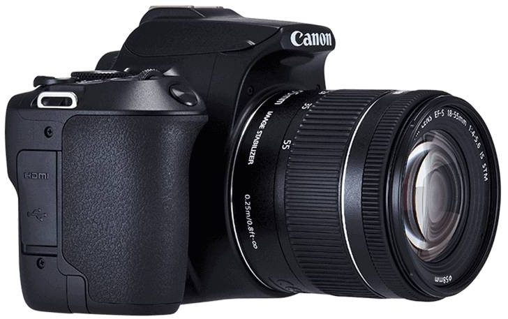 Appareil photo Canon noir sur fond blanc. Objectif et boutons visibles. Logo Canon. L'appareil photo est incliné.