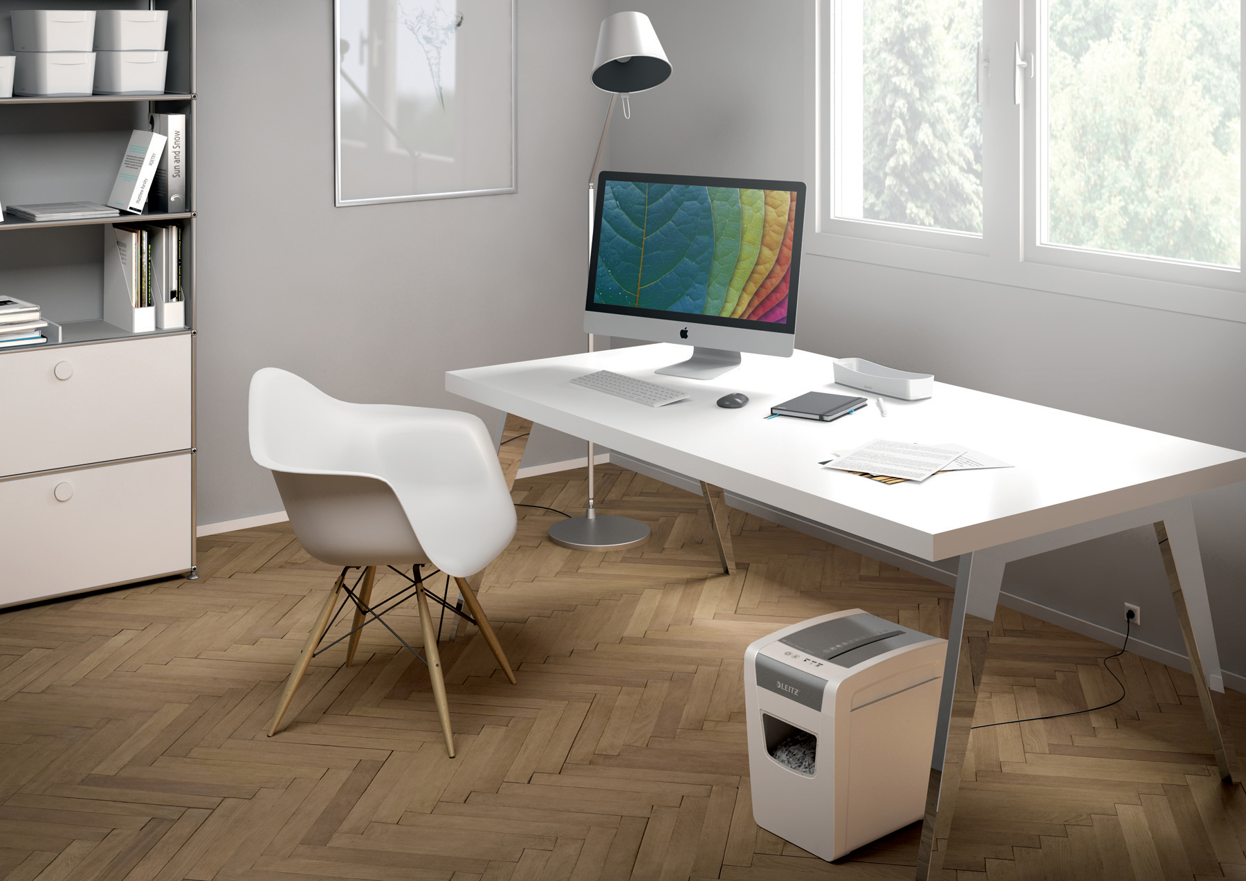 Ein modernes Büro. Ein weißer Schreibtisch mit Computer, Stuhl und Aktenvernichter. Holzfußboden.
