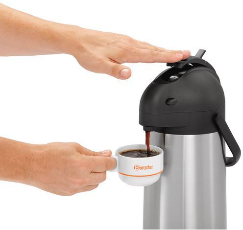 Eine Person gießt Kaffee aus einer Edelstahl-Thermoskanne in eine Tasse.