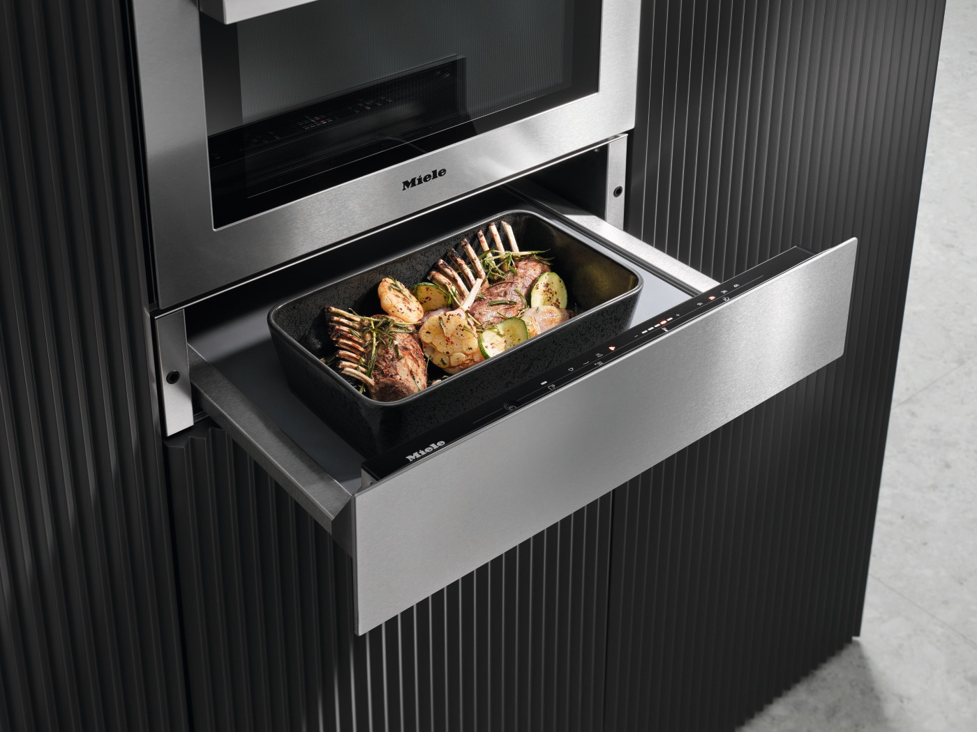 Kitchen cabinet with open drawer revealing a tray of cooked lamb chops.