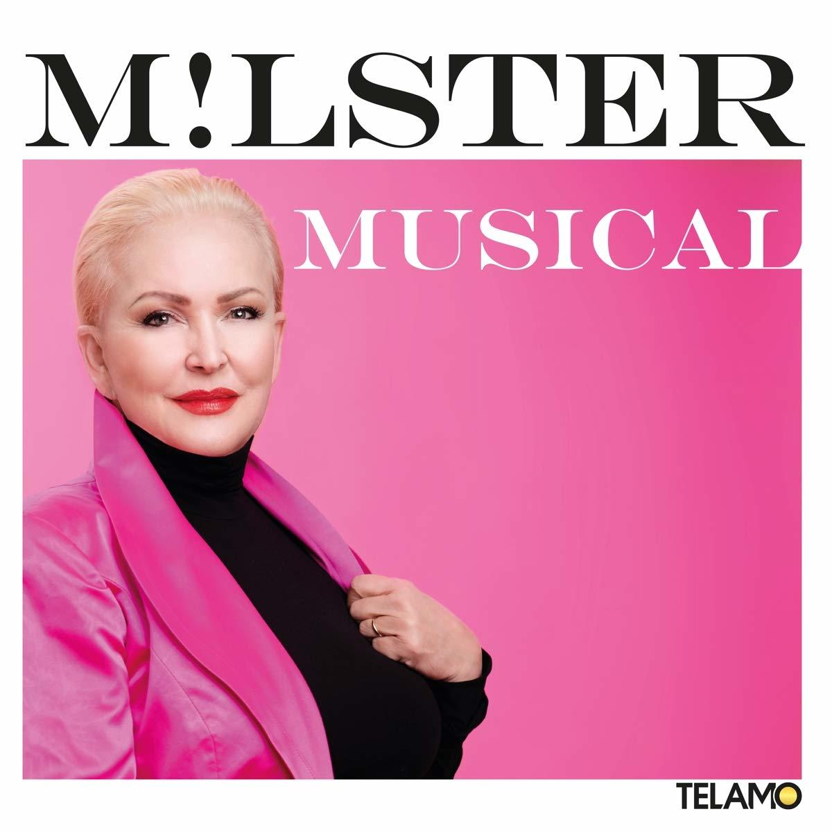 Blonde Frau in pinkfarbenem Mantel vor pinkfarbenem Hintergrund. Text: M!LSTER MUSICAL.