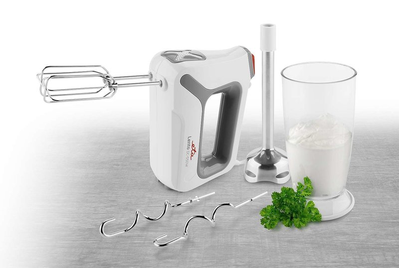 Fehér kézi mixer, tartozékok, petrezselyem és egy pohár fehér krém.