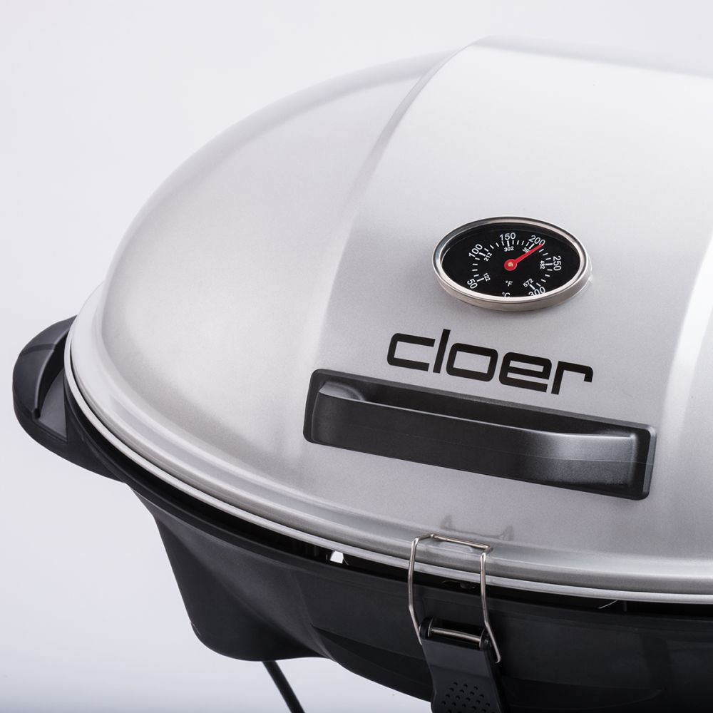 Silberner Grill mit schwarzem Griff, Thermometer und dem Wort 'CLOER'. Weißer Hintergrund.