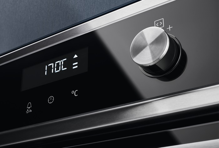 A sütő kezelőpaneljének közeli képe, digitális kijelzővel és gombbal.