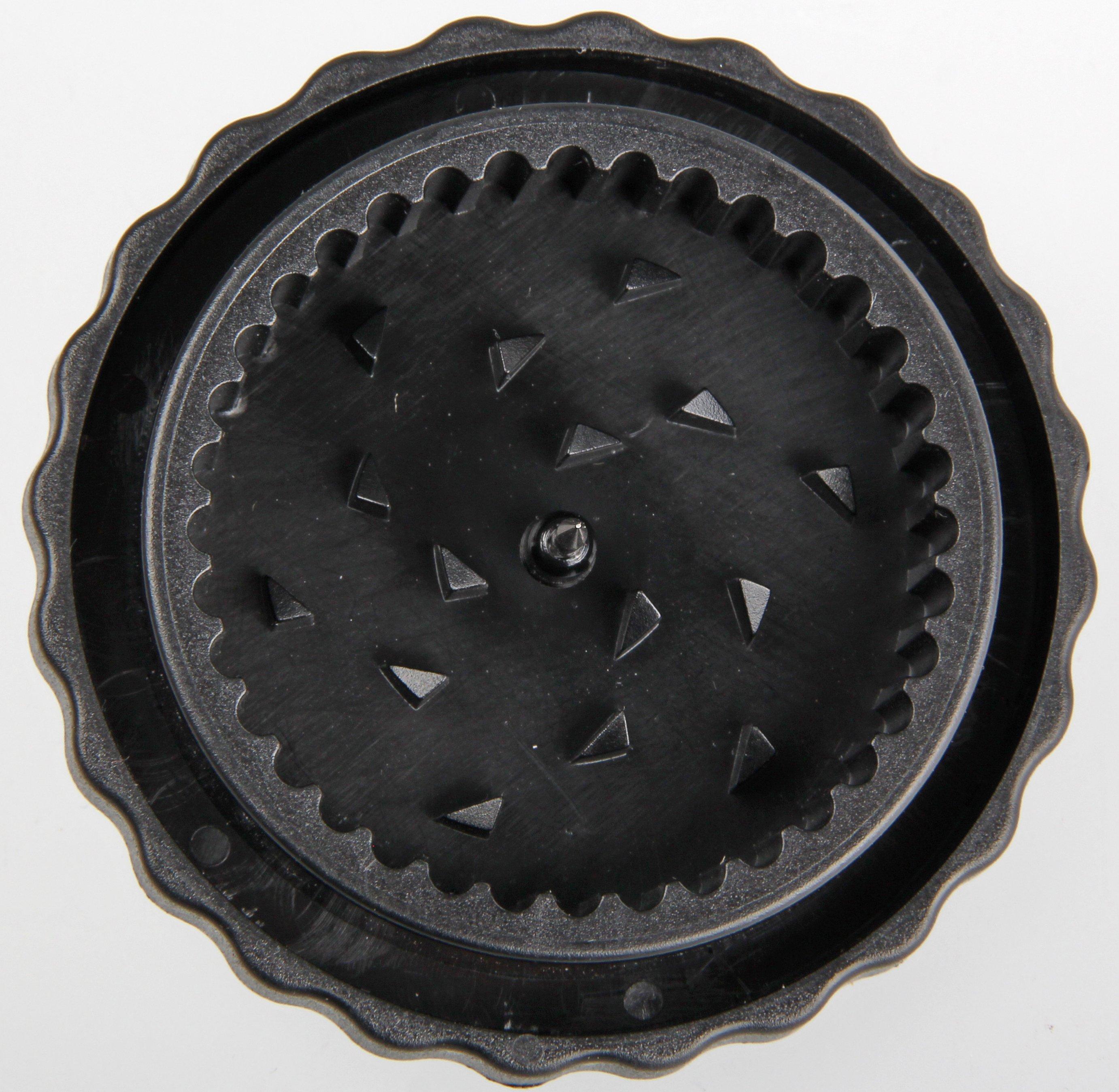 Schwarzer Grinder mit dreieckigen Zähnen. Der Grinder ist kreisförmig mit strukturierter Oberfläche.