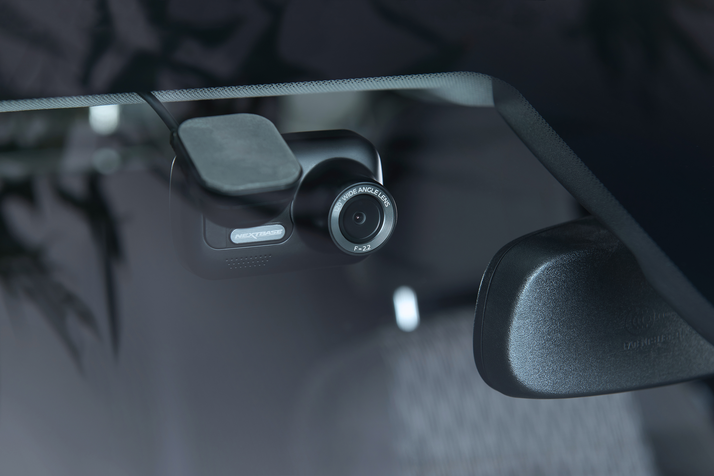 Eine schwarze Dashcam, die in einem Auto installiert ist, mit Blick auf die Windschutzscheibe.