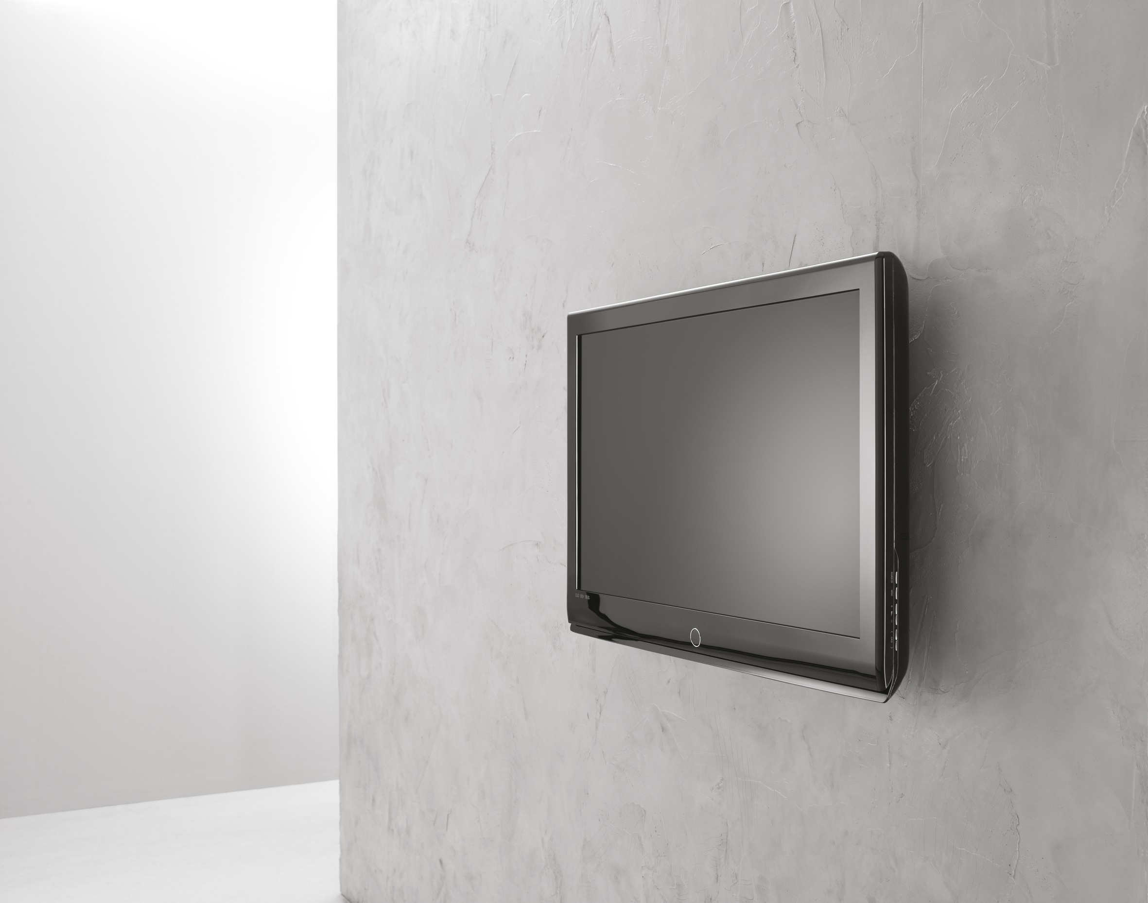 Un televisor de pantalla plana montado en una pared gris clara y texturizada. Pared blanca a la izquierda.