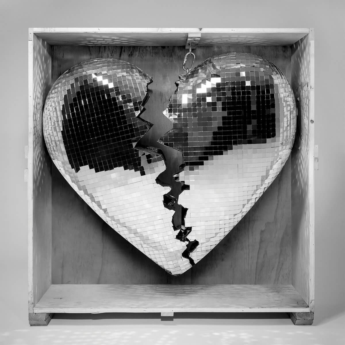 Cœur de boule disco brisé à l'intérieur d'une boîte en bois. Image en noir et blanc.