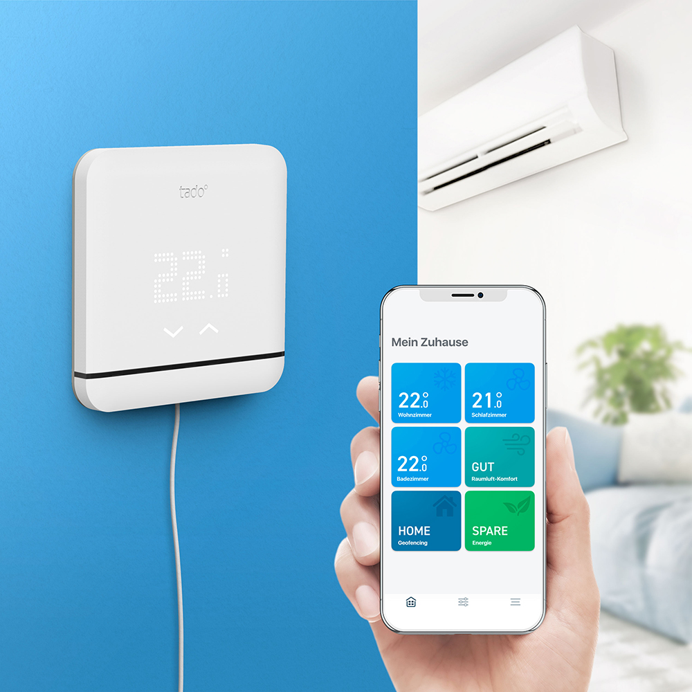 Ein Smart-Home-Thermostat zeigt die Temperatur an. Ein Smartphone zeigt eine Home-Control-App.